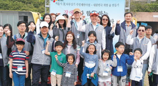 지난달 30일 서울 광나루 한강공원에서 온실가스 감축을 위한 '장애인과 함께하는 탄소상쇄 도시숲' 조성 행사에 참여한 CJ대한통운 임직원과 희망나누미 봉사자, 장애인, 시민 등이 기념사진을 찍고 있다. CJ대한통운 제공